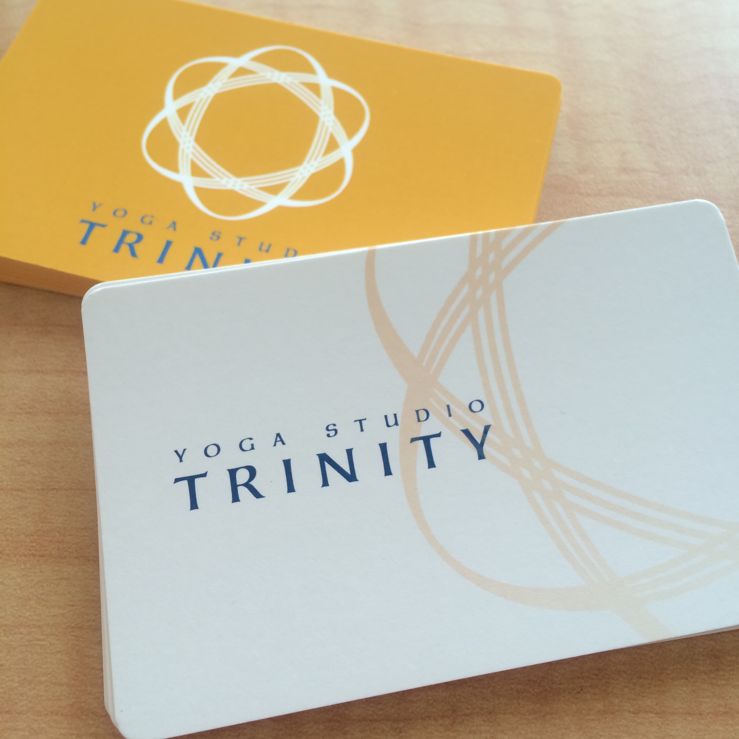YOGA STUDIO TRINITY のブランドカードと TRINITY ロゴマーク